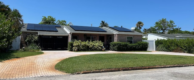 ranch-style house with a front lawn and solar panels