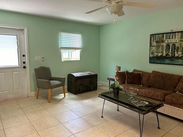 tiled living room with ceiling fan, a healthy amount of sunlight, and a textured ceiling