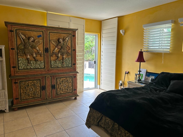 tiled bedroom featuring access to exterior and a textured ceiling