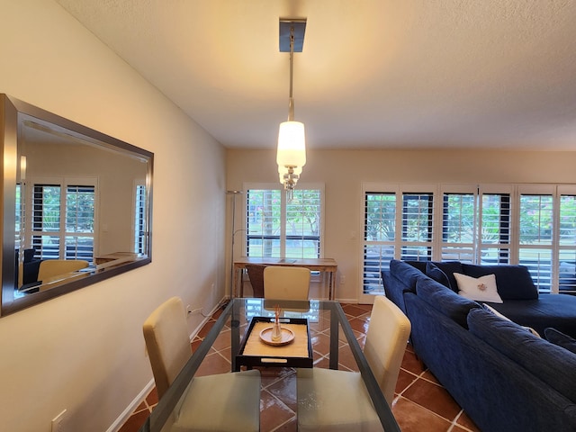 dining area featuring tile patterned floors, a healthy amount of sunlight, and a textured ceiling