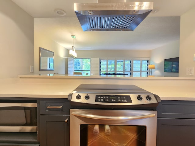 kitchen featuring pendant lighting, stainless steel appliances, and extractor fan