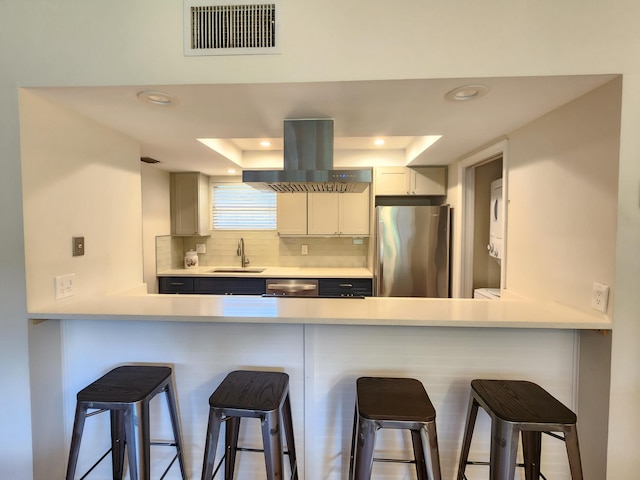 kitchen with stainless steel fridge, backsplash, extractor fan, sink, and white cabinets