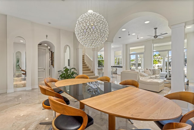 dining room with ceiling fan with notable chandelier and ornate columns