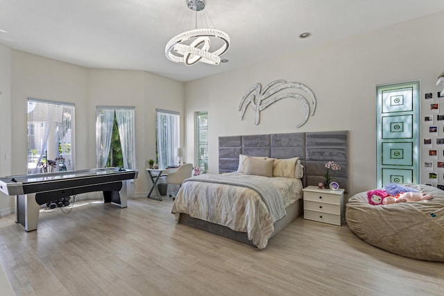 bedroom featuring light hardwood / wood-style flooring and an inviting chandelier