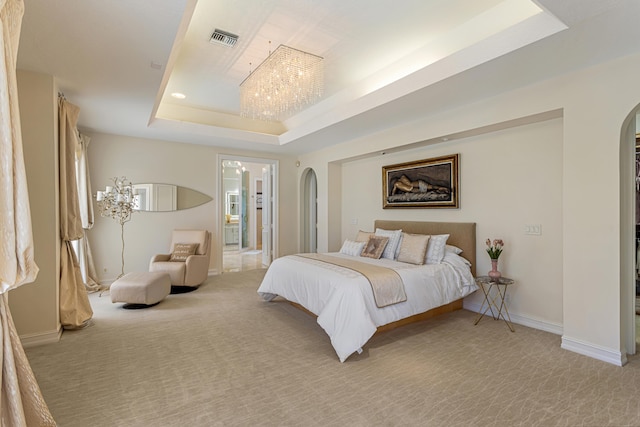 bedroom featuring a raised ceiling, light colored carpet, and an inviting chandelier