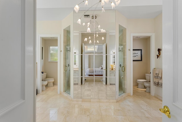 bathroom with a chandelier, toilet, and a bidet