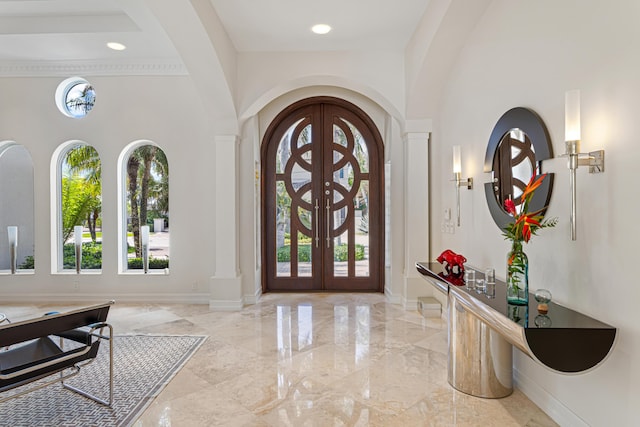 foyer entrance with a high ceiling, a wealth of natural light, and french doors