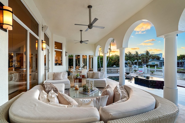 patio terrace at dusk featuring an outdoor bar and ceiling fan