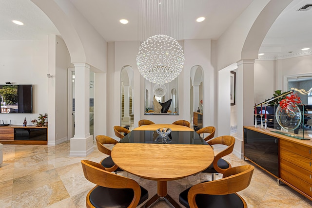 dining room with a chandelier and decorative columns