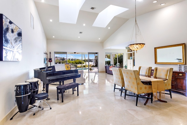 dining area featuring a skylight, high vaulted ceiling, and an inviting chandelier