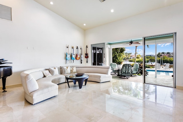 living room with ceiling fan and a high ceiling