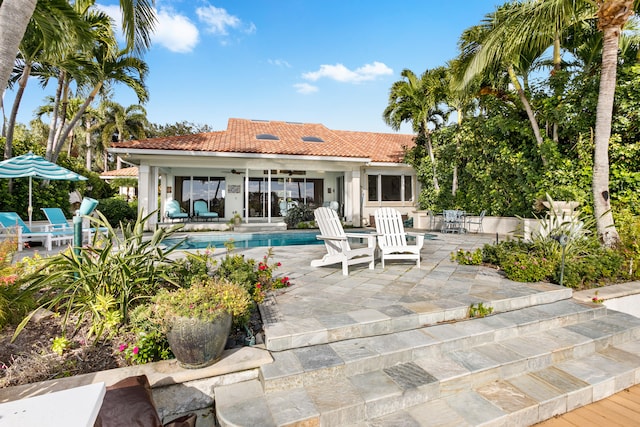 rear view of property featuring ceiling fan and a patio