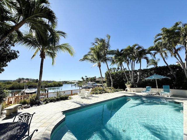 view of swimming pool with a patio area and a water view