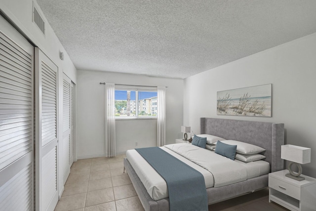 bedroom featuring light tile patterned floors and a textured ceiling