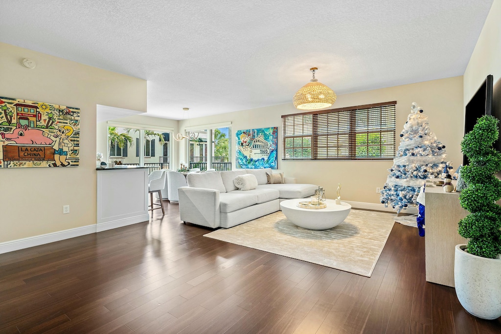 living room with a textured ceiling and dark hardwood / wood-style flooring