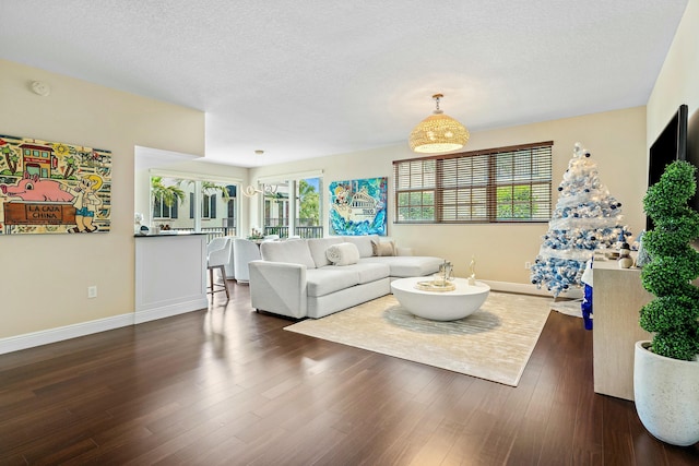 living room with a textured ceiling and dark hardwood / wood-style flooring