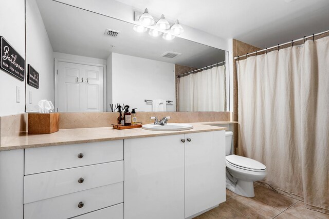 bathroom with tile flooring, vanity, and toilet