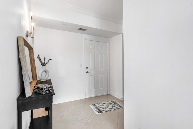 tiled foyer entrance featuring crown molding