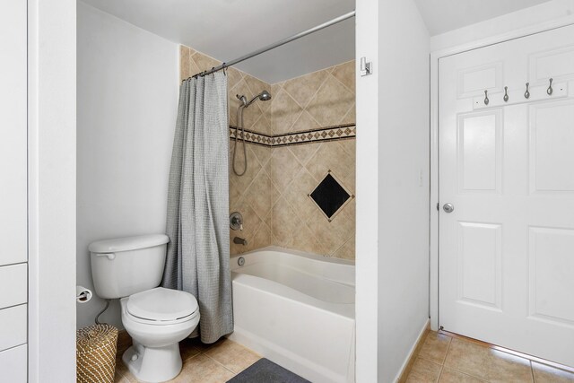 bathroom with tile floors, shower / tub combo with curtain, and toilet