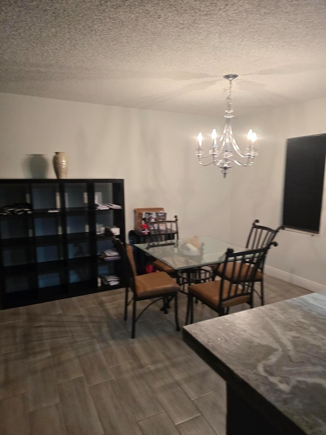 dining room featuring a textured ceiling, hardwood / wood-style flooring, and a notable chandelier