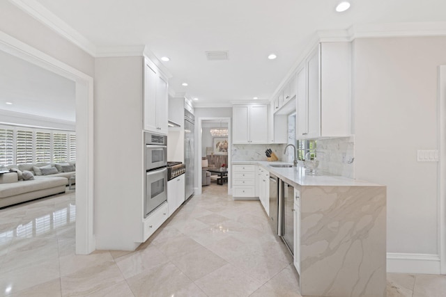 kitchen featuring sink, decorative backsplash, light stone countertops, ornamental molding, and white cabinetry