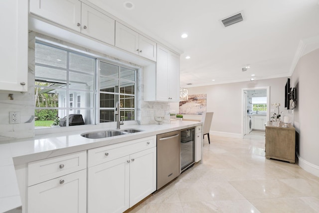 kitchen with stainless steel dishwasher, backsplash, a healthy amount of sunlight, and sink