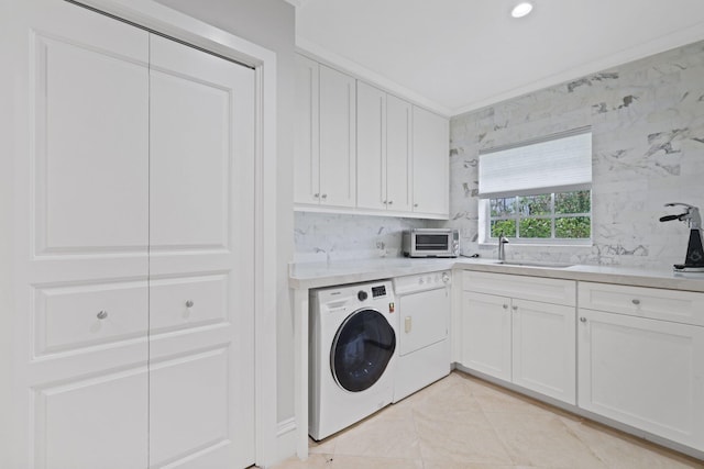 washroom featuring cabinets, sink, separate washer and dryer, ornamental molding, and light tile patterned flooring