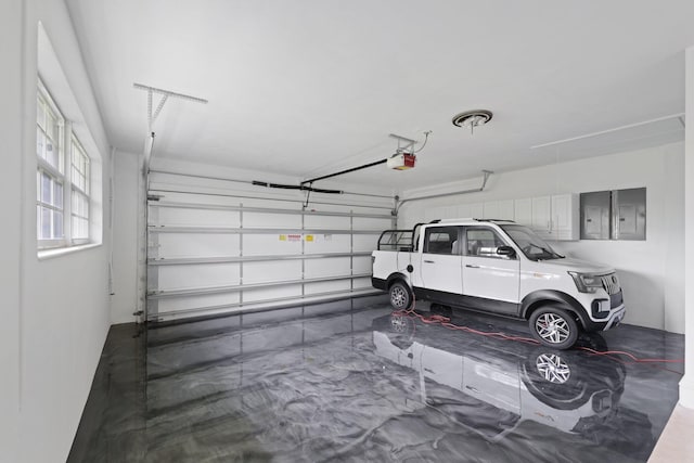 garage with a garage door opener and electric panel