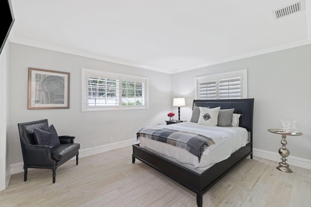 bedroom with light wood-type flooring and crown molding