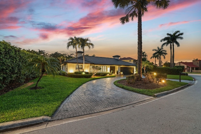 ranch-style home featuring a garage and a yard