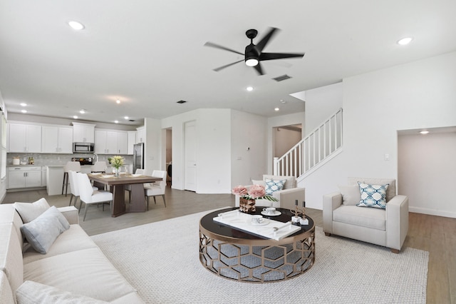 living room with light hardwood / wood-style floors and ceiling fan