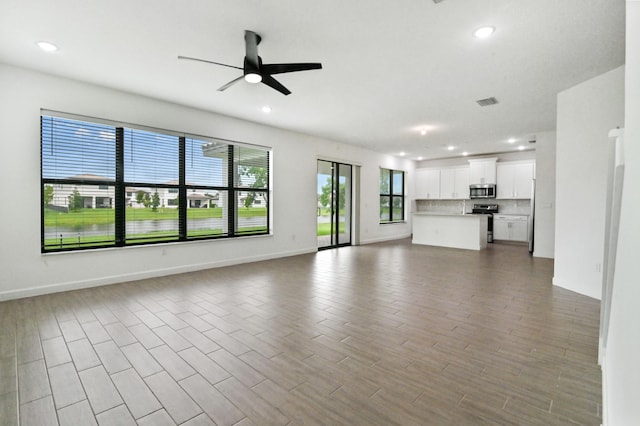 unfurnished living room with ceiling fan and hardwood / wood-style floors