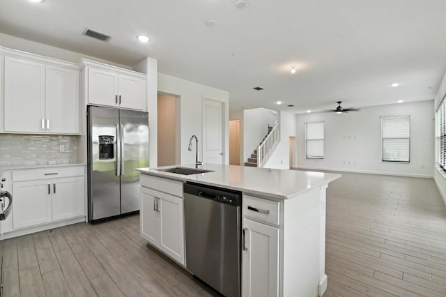 kitchen featuring an island with sink, white cabinetry, appliances with stainless steel finishes, and sink