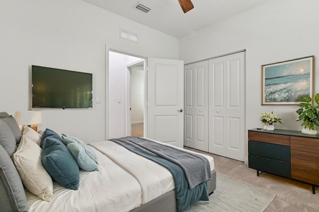 bedroom with ceiling fan, light colored carpet, and a closet