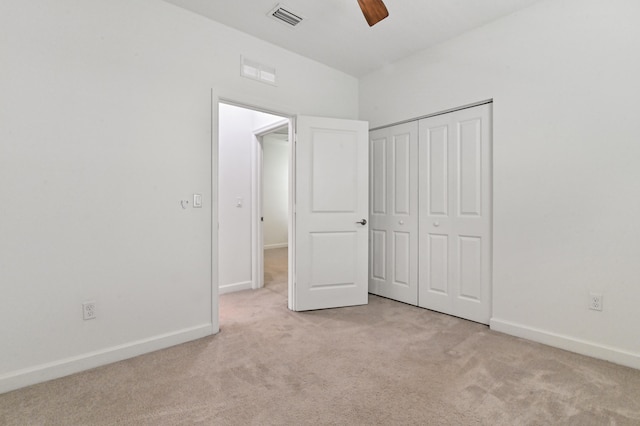 unfurnished bedroom featuring a closet, ceiling fan, and light colored carpet