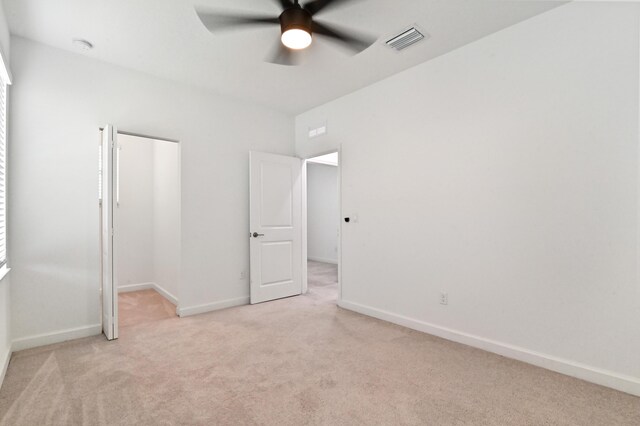 unfurnished bedroom with ceiling fan and light colored carpet