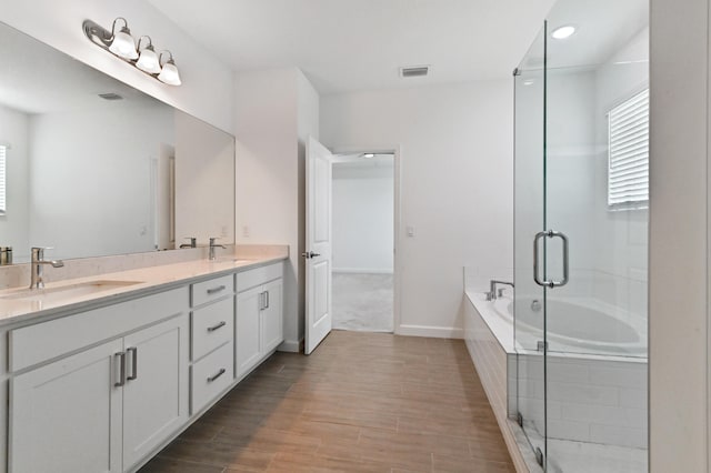 bathroom with shower with separate bathtub, hardwood / wood-style floors, and vanity