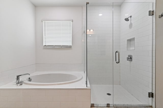 bathroom featuring independent shower and bath