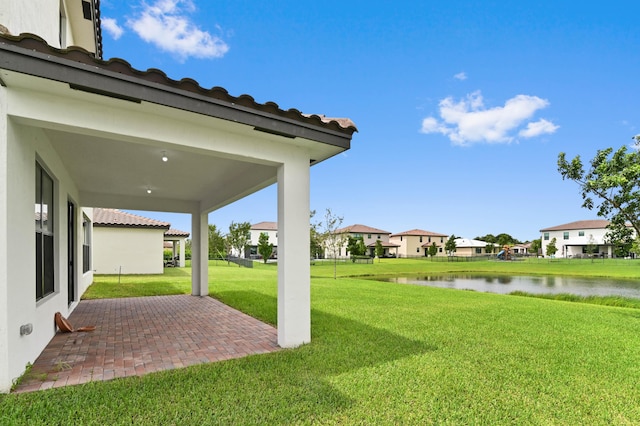 view of yard featuring a water view and a patio area