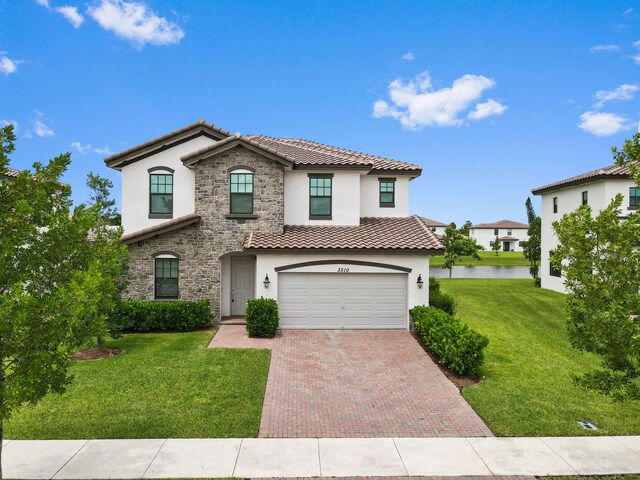 mediterranean / spanish home featuring a front yard and a garage