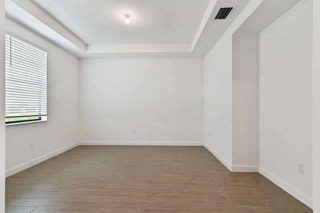 unfurnished room featuring a raised ceiling and hardwood / wood-style flooring