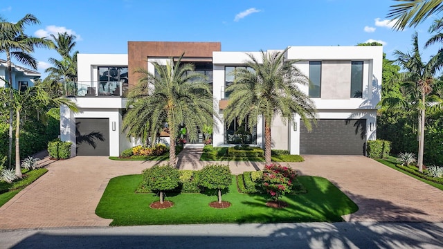 contemporary home featuring a garage, a balcony, and a front yard