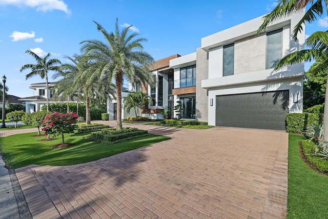 view of front of home with a front yard and a garage