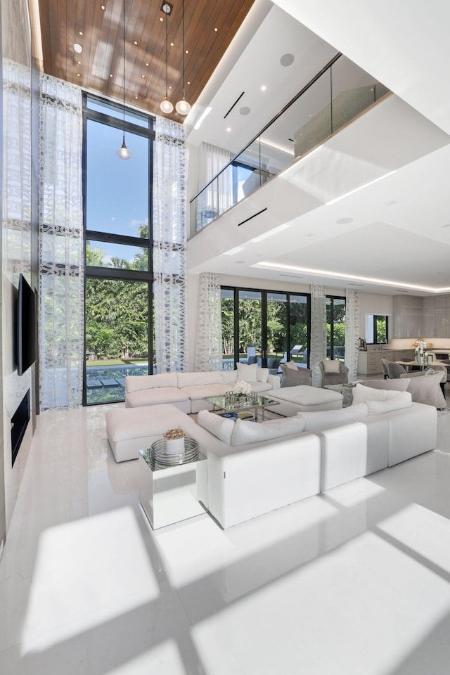 living room with a high ceiling and floor to ceiling windows