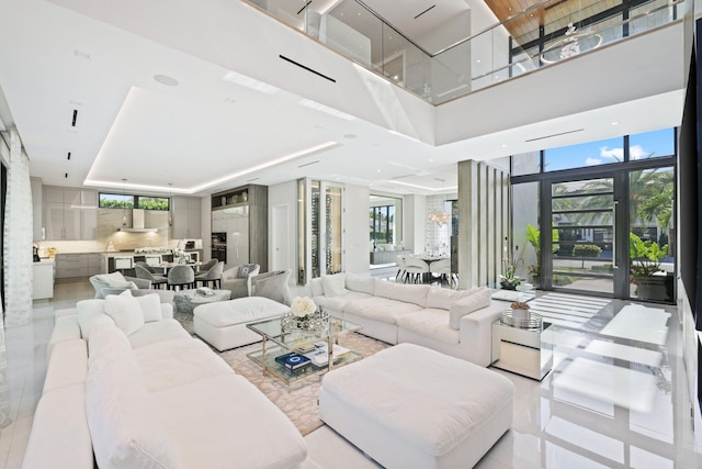 living room with floor to ceiling windows, light tile patterned floors, and a high ceiling