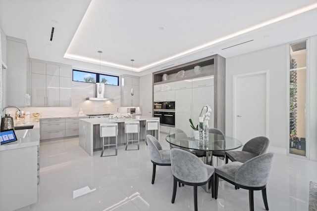 dining space with a tray ceiling and sink