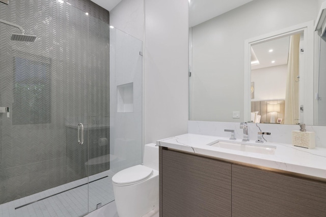 bathroom with walk in shower, vanity, and toilet