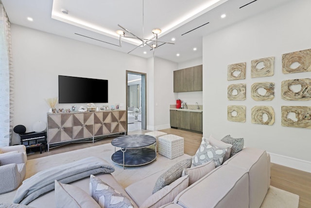 living room with an inviting chandelier and light hardwood / wood-style flooring