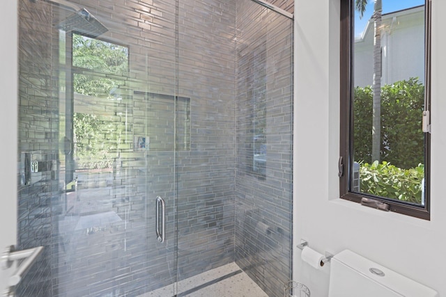 bathroom featuring an enclosed shower and toilet