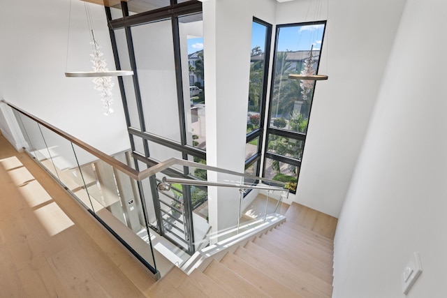 stairs featuring hardwood / wood-style floors and floor to ceiling windows